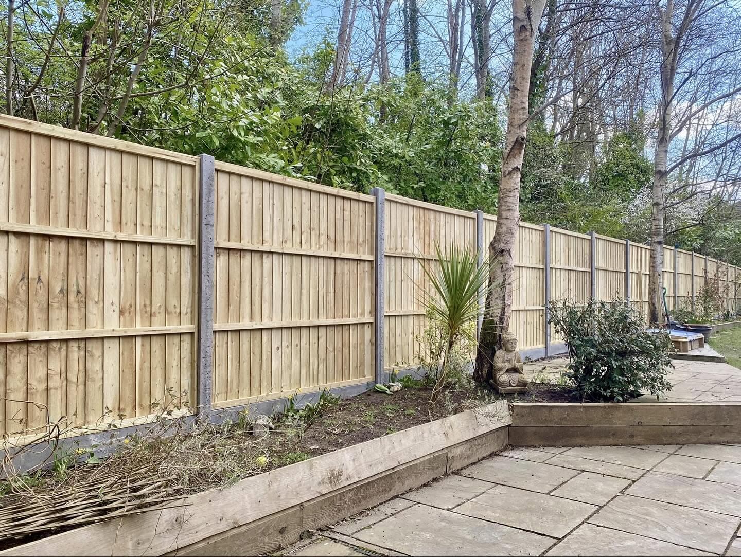 Closeboard fencing on concrete posts behind a sleeper-edged bed and patio, built by Fencecraft Closeboard fencing on concrete posts behind a sleeper-edged bed and patio, built by Fencecraft