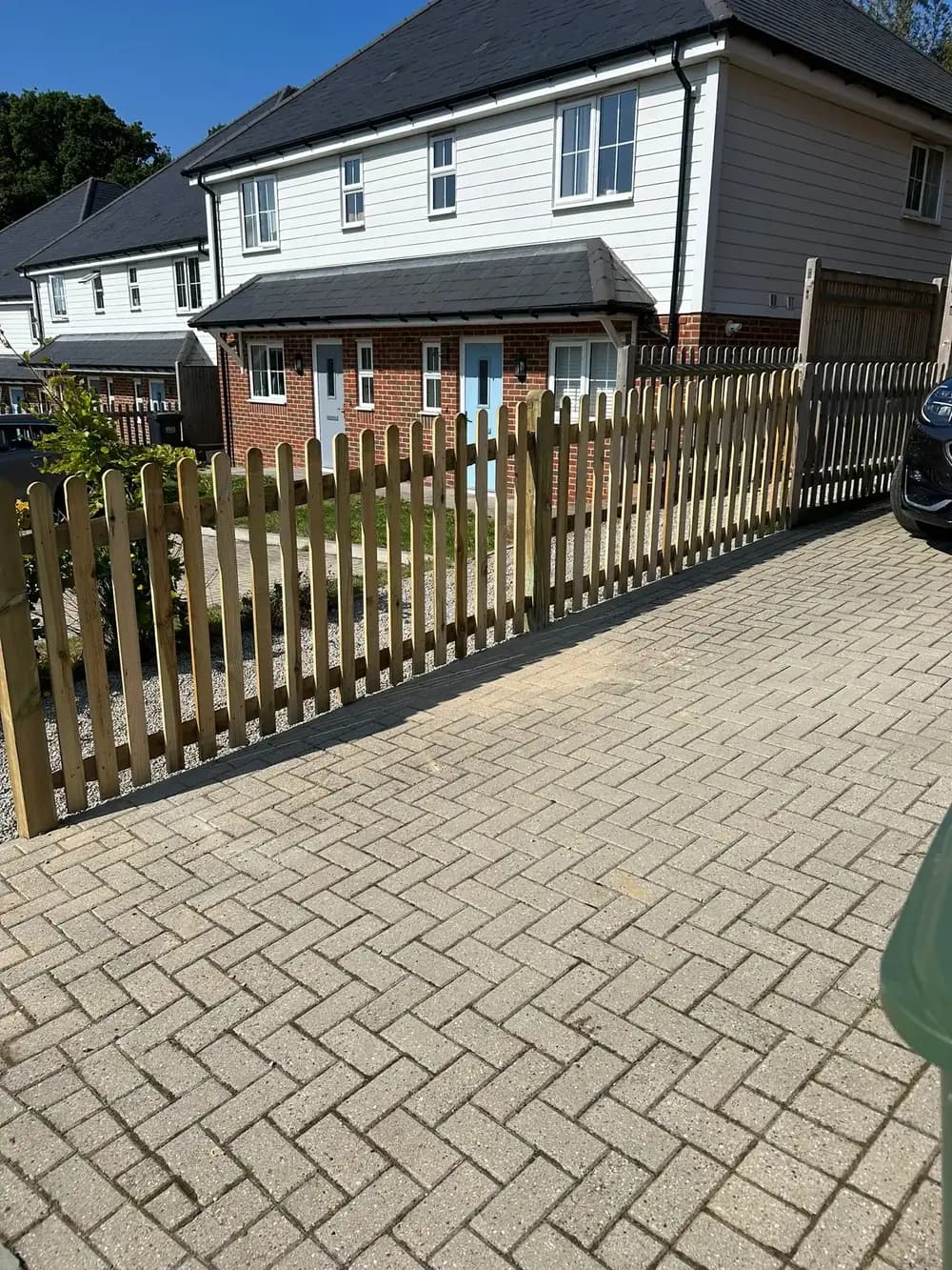 Round-top timber picket fence along a block-paved driveway, built by Fencecraft in Kent Round-top timber picket fence along a block-paved driveway, built by Fencecraft in Kent
